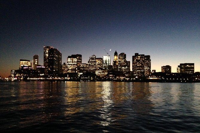 Boston Harbor Night Cruise - USS Constitution and Bunker Hill Monument lit up from the harbor